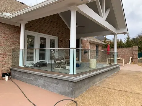 A covered back porch on a house with a custom glass panel railing around it by Glass Doctor of Nashville.