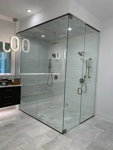 Frameless clear glass panels enclosing a shower with textured white walls installed by Glass Doctor of Nashville.