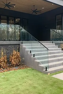Decorative glass panels installed by Glass Doctor of Nashville create a custom railing around a porch and down a set of steps.